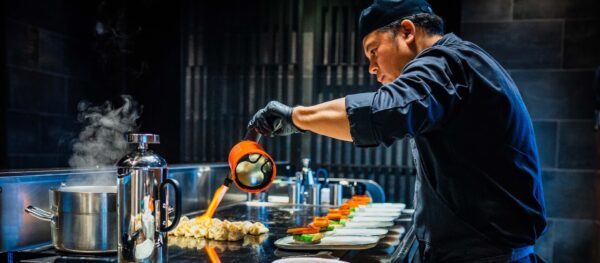 Chef preparing dumplings with handheld burner