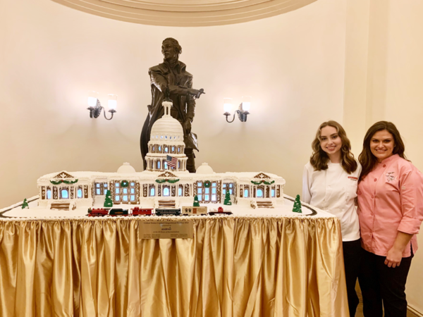 Molly Donahue and Faith Weber (left to right) present their U.S. Capitol Gingerbread Replica at the U.S. House of Representatives on November 29, 2022.