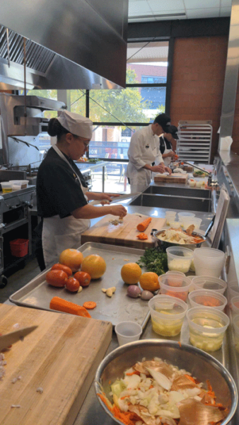 Photo of two chefs working in the kitchen during a ACTP 2023 class 