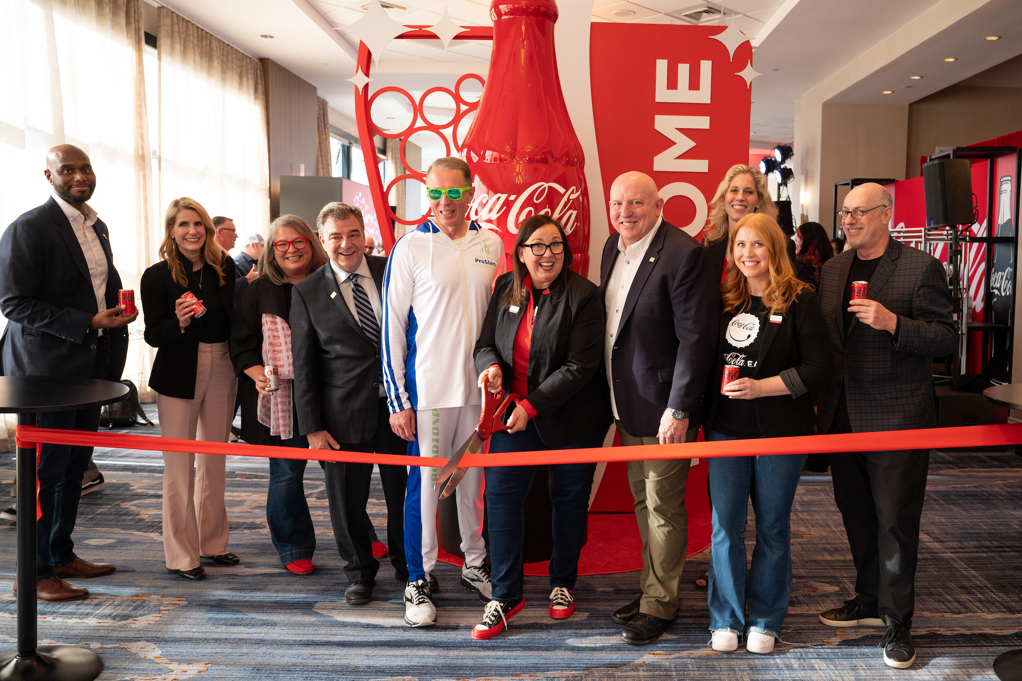 Paula Weeks of Coca-Cola, Sean Beard, Chair of the NRAEF Board of Trustees, Rob Gifford, President of NRAEF, and other attendees at the Coca-Cola Lounge ribbon cutting.